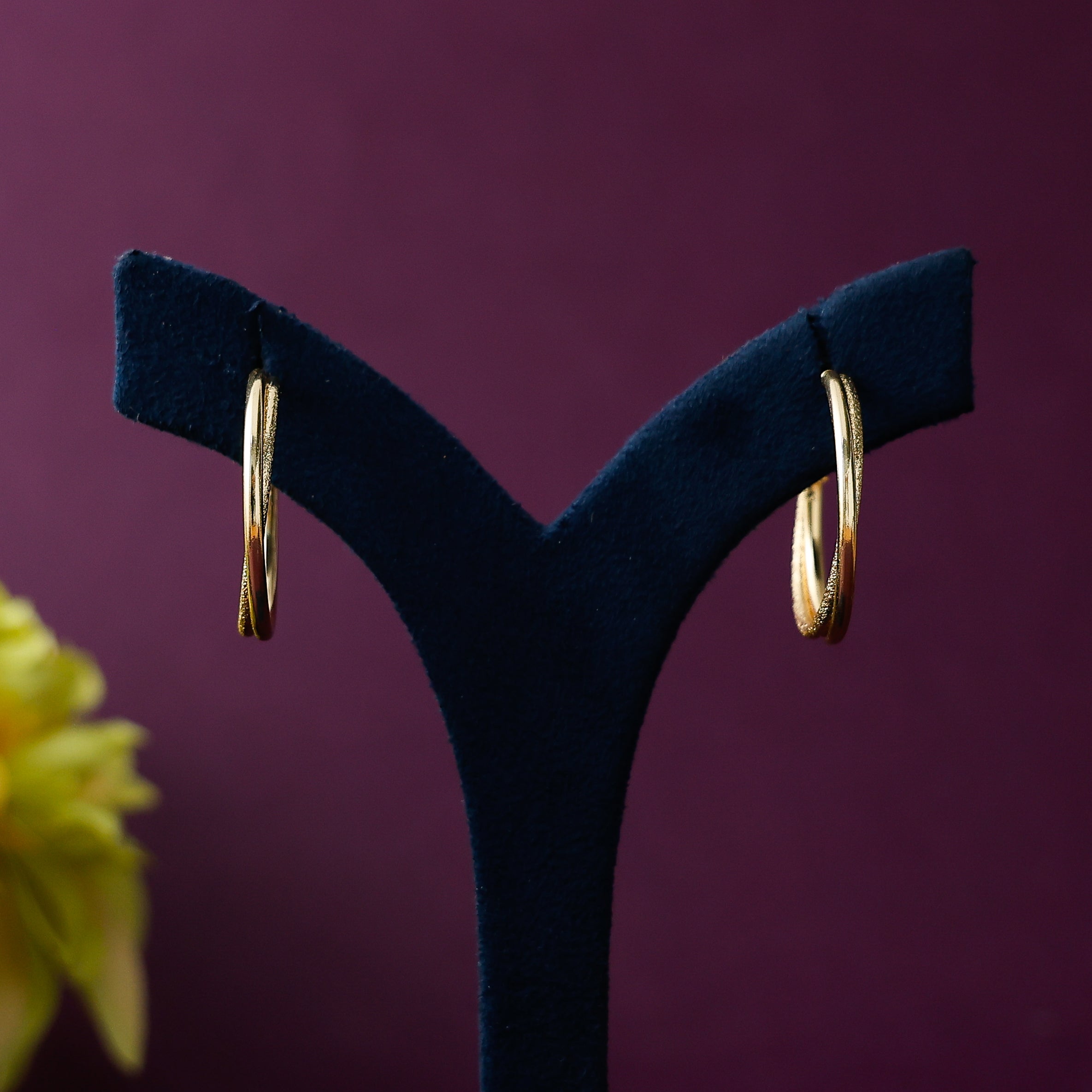 Stylish crossed hoops with textured gold-tone finish